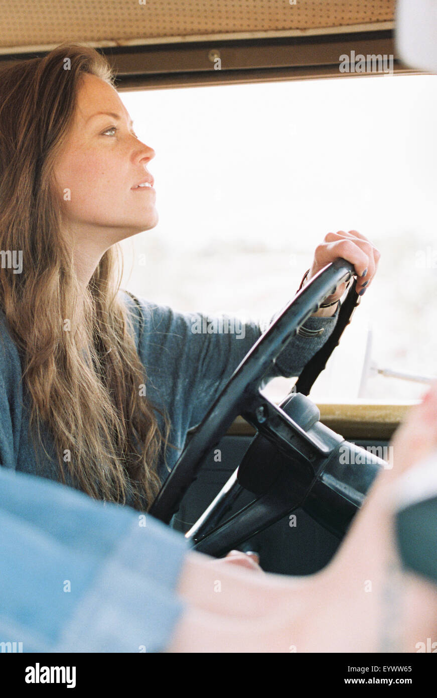 Femme aux pieds nus reposant ses pieds sur le tableau de bord d'un 4x4, un tatouage sur son pied droit, une autre femme au volant. Banque D'Images
