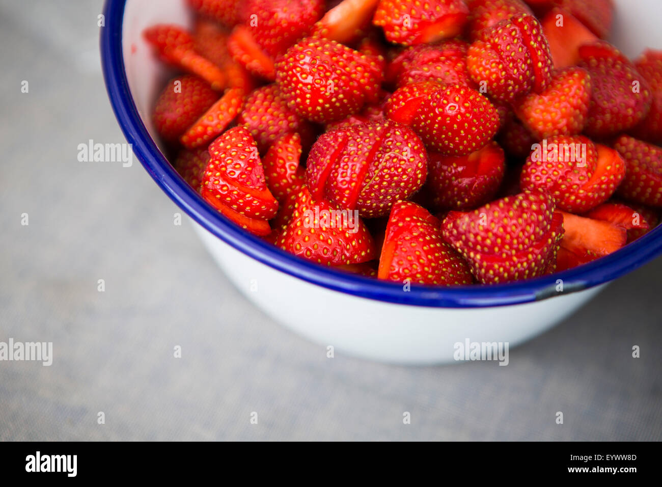 Les fraises en bleu cerclée blanc bol en métal. Banque D'Images