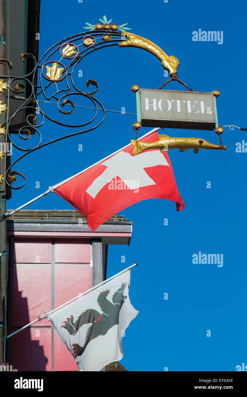 Appenzell, Appenzell Rhodes-Intérieures Canton, Suisse. Inscrivez-vous à l'extérieur de l'hôtel. Drapeau suisse. Le drapeau de l'ours est le pavillon de l'Appenzall Banque D'Images