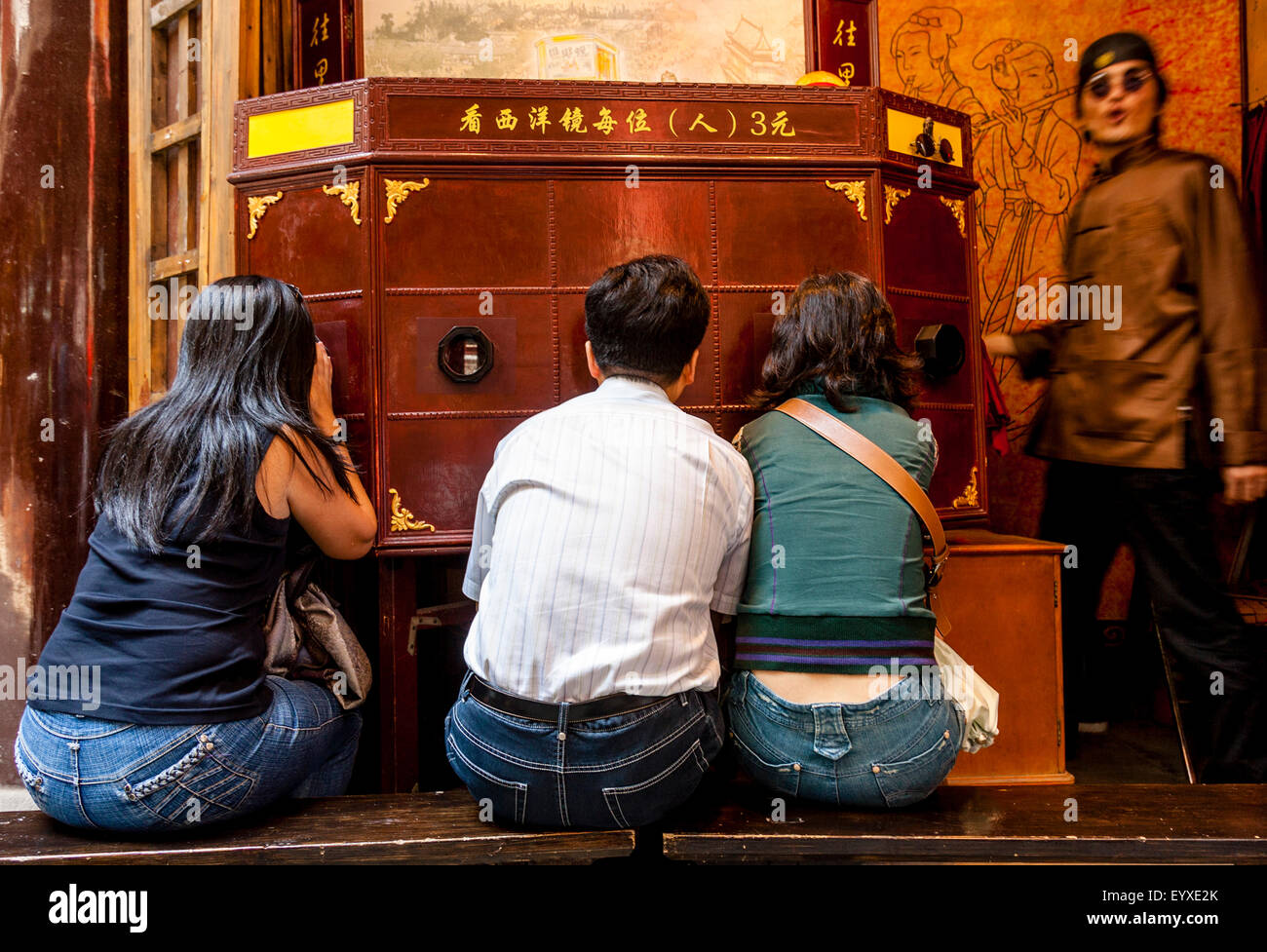 Les gens regardent un peep-show traditionnel chinois, le vieux Shanghai, Shanghai, Chine Banque D'Images