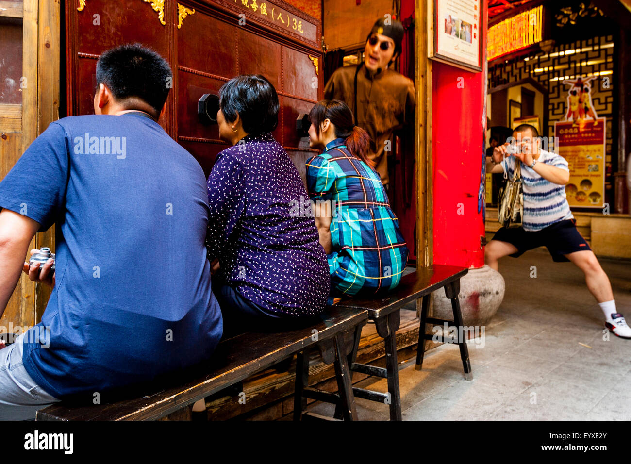 Un homme prend une photo de personnes regardant un peep-show traditionnel chinois, le vieux Shanghai, Shanghai, Chine Banque D'Images