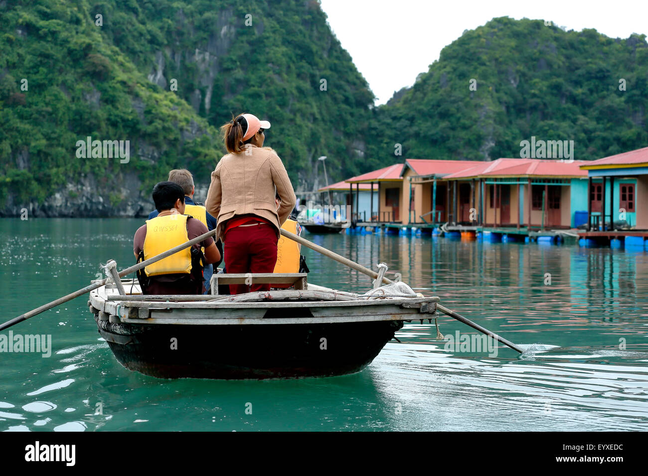 Les touristes sur des bateaux à rames et des maisons flottantes, village de pêcheurs de Vung Vieng, Ha Long Bay, Secteur de Bai Tu Long, Vietnam Banque D'Images