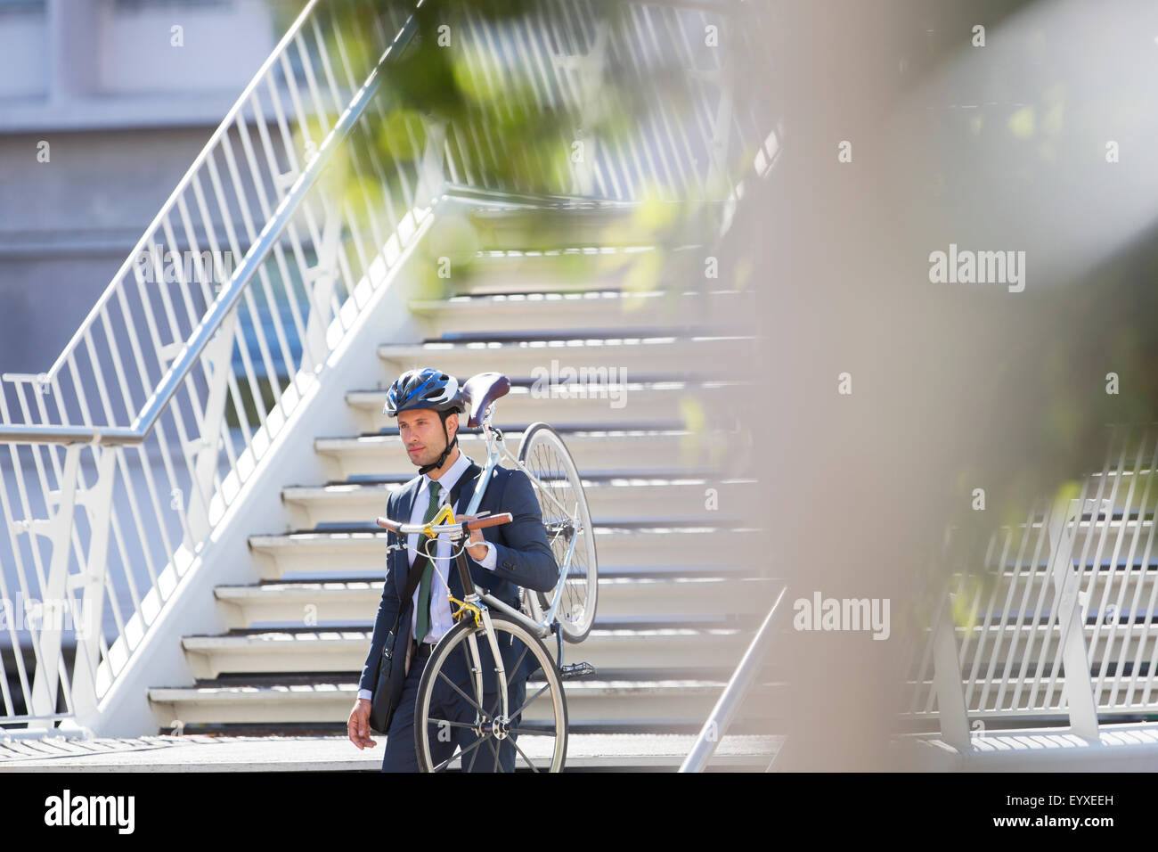 Man in suit et le casque de vélo urbain transportant vers le bas des escaliers Banque D'Images