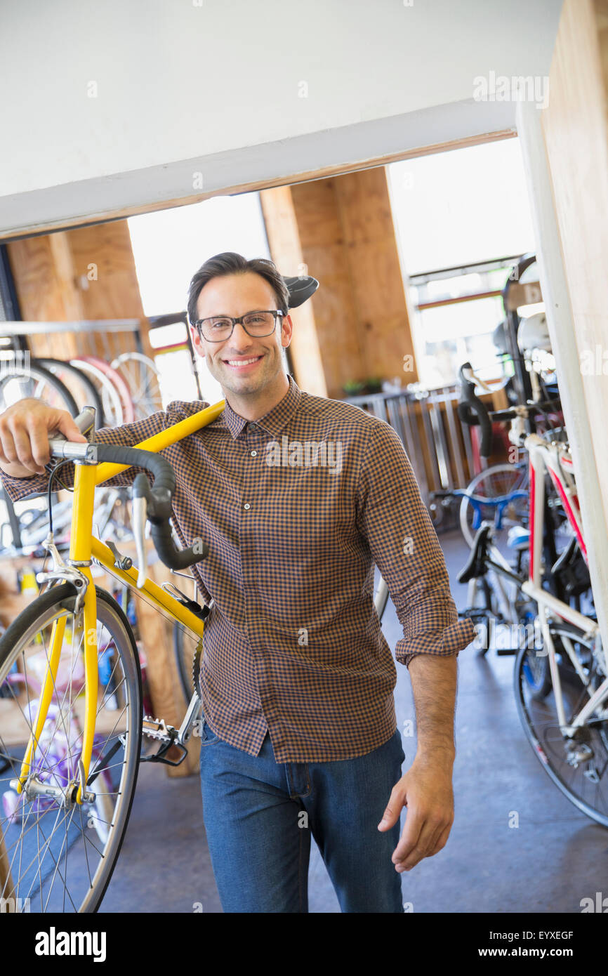 Portrait of smiling man with eyeglasses exerçant son magasin de vélos en location Banque D'Images