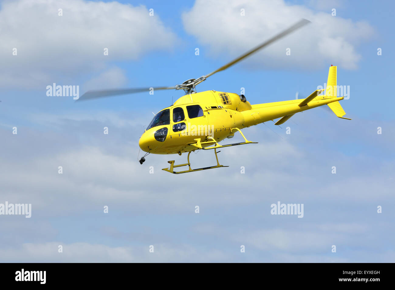 Hélicoptère de sauvetage par hélicoptère, jaune dans l'air tout en volant sur ciel bleu. Tous les logos et le texte supprimé. Banque D'Images