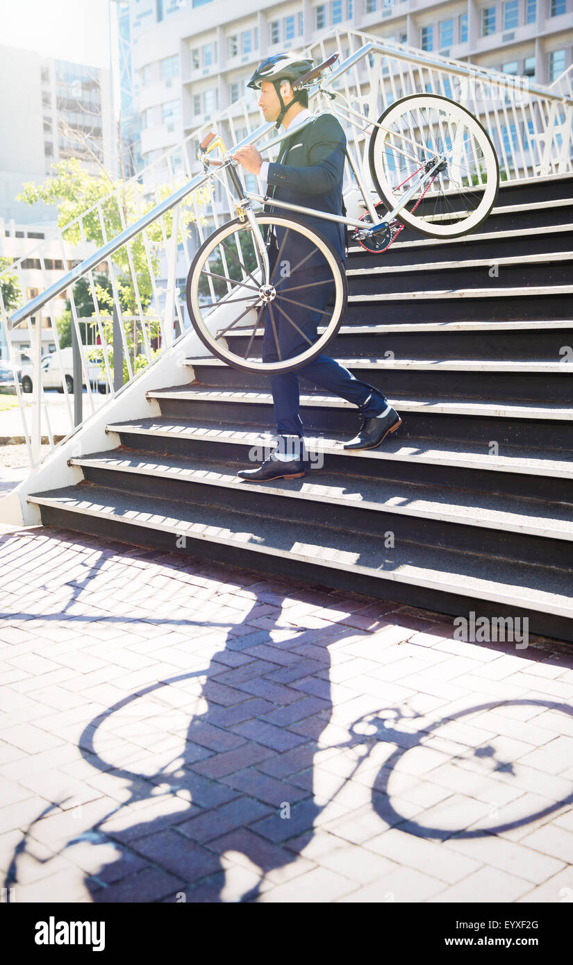 Man in suit et le casque de vélo urbain transportant vers le bas des escaliers Banque D'Images