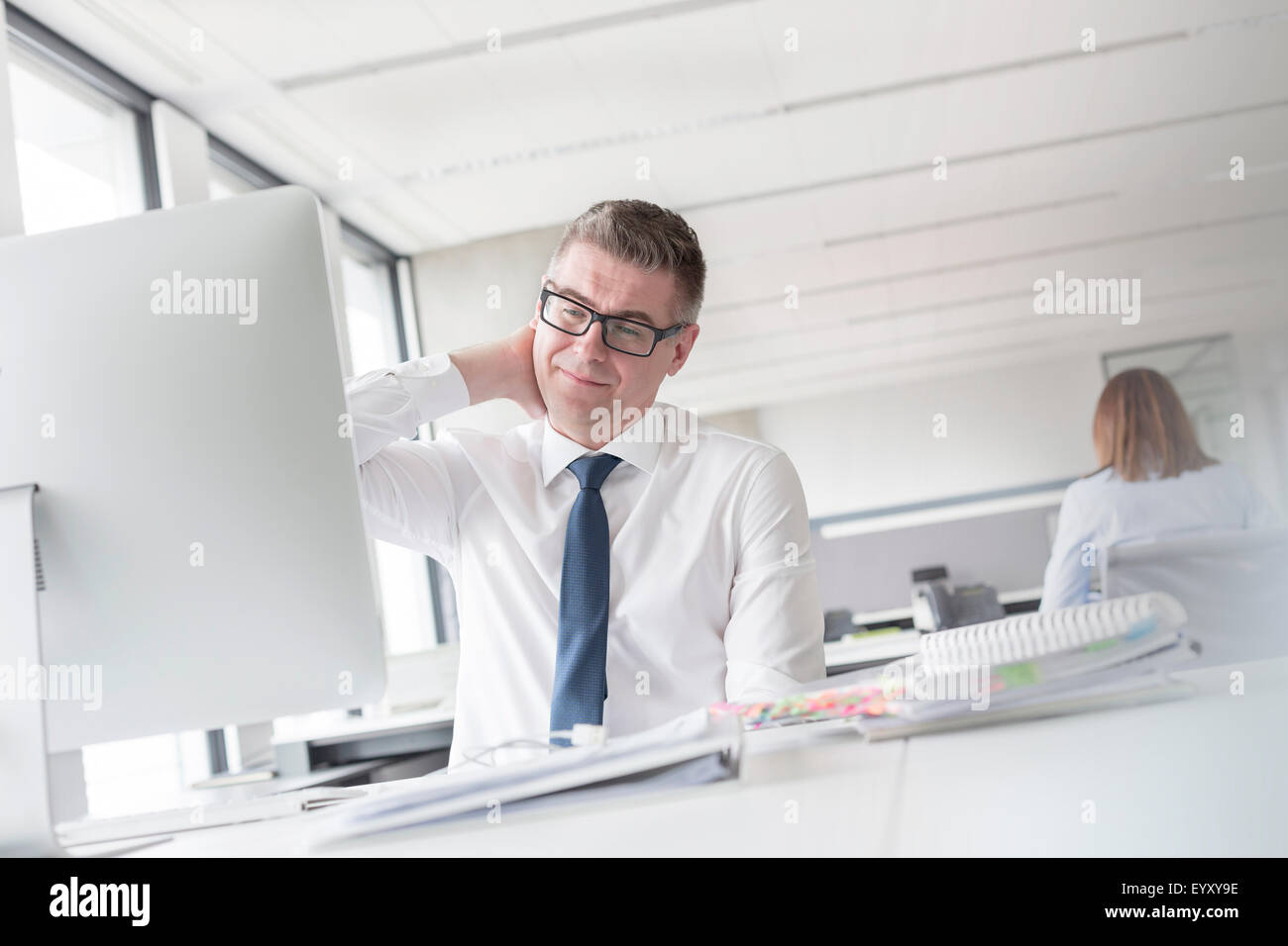 Businessman se frottant le cou at computer in office Banque D'Images