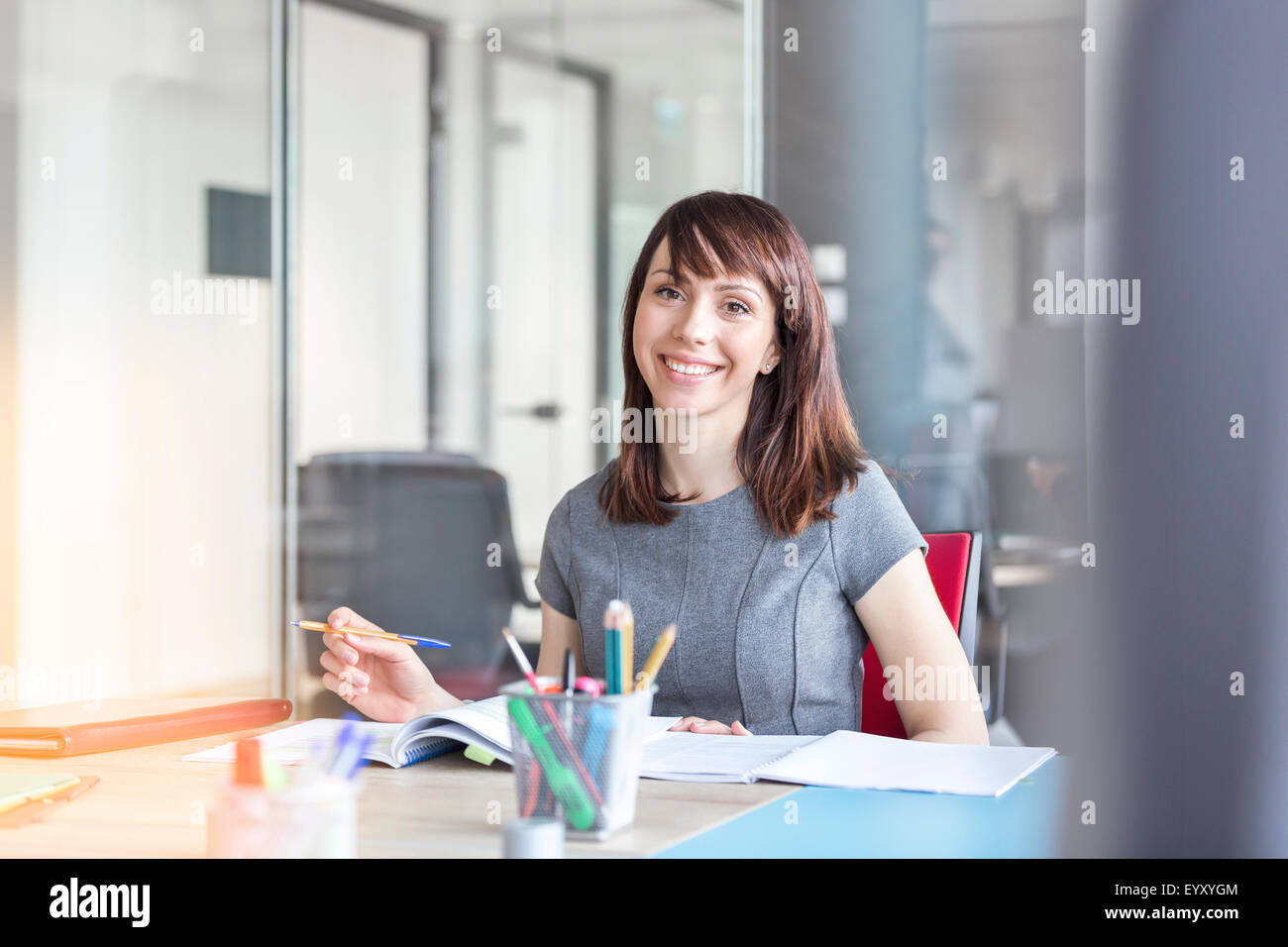 Portrait confiant brunette businesswoman working in conference room Banque D'Images