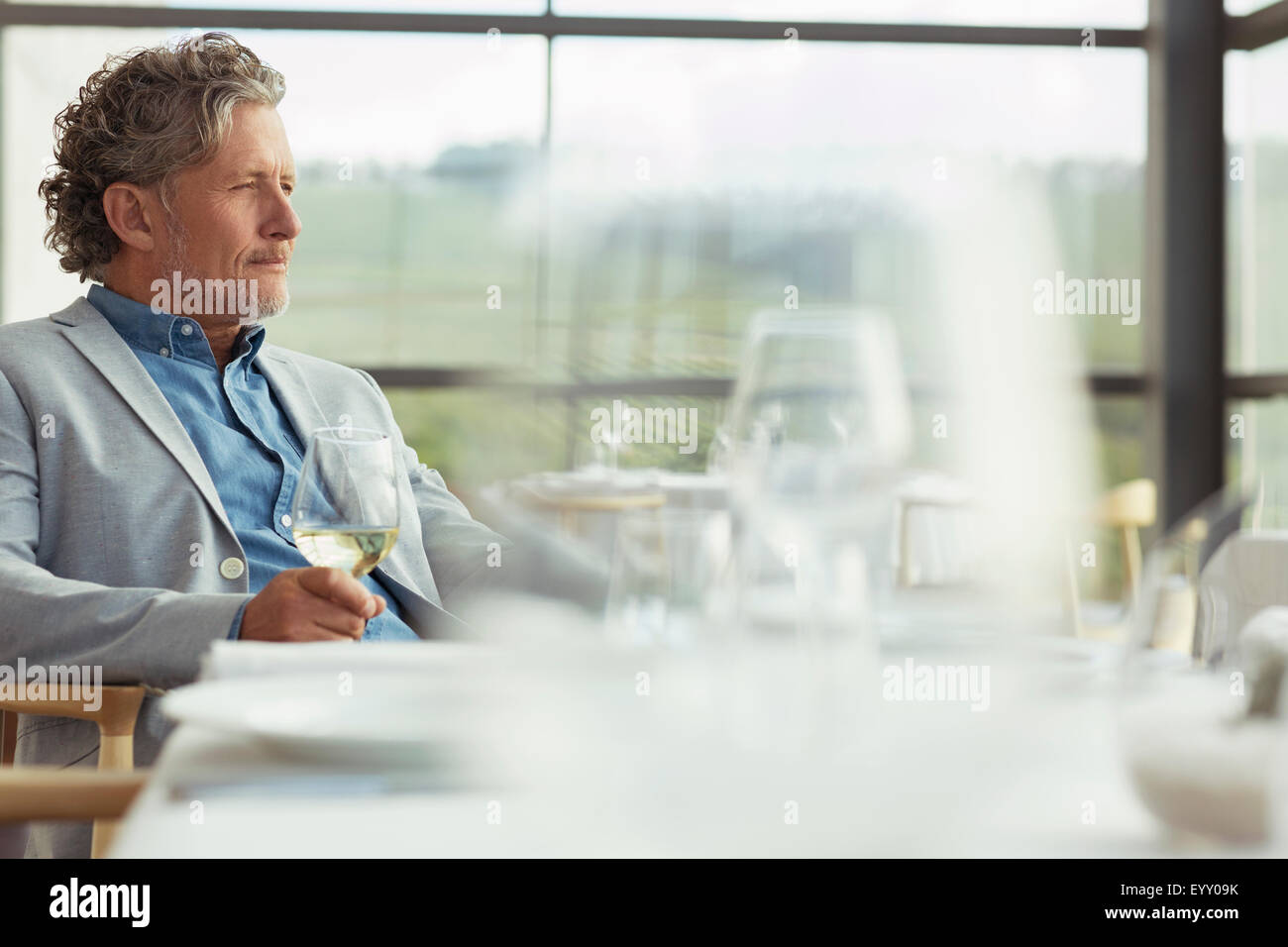 Pensive man drinking white wine winery en salle à manger Banque D'Images