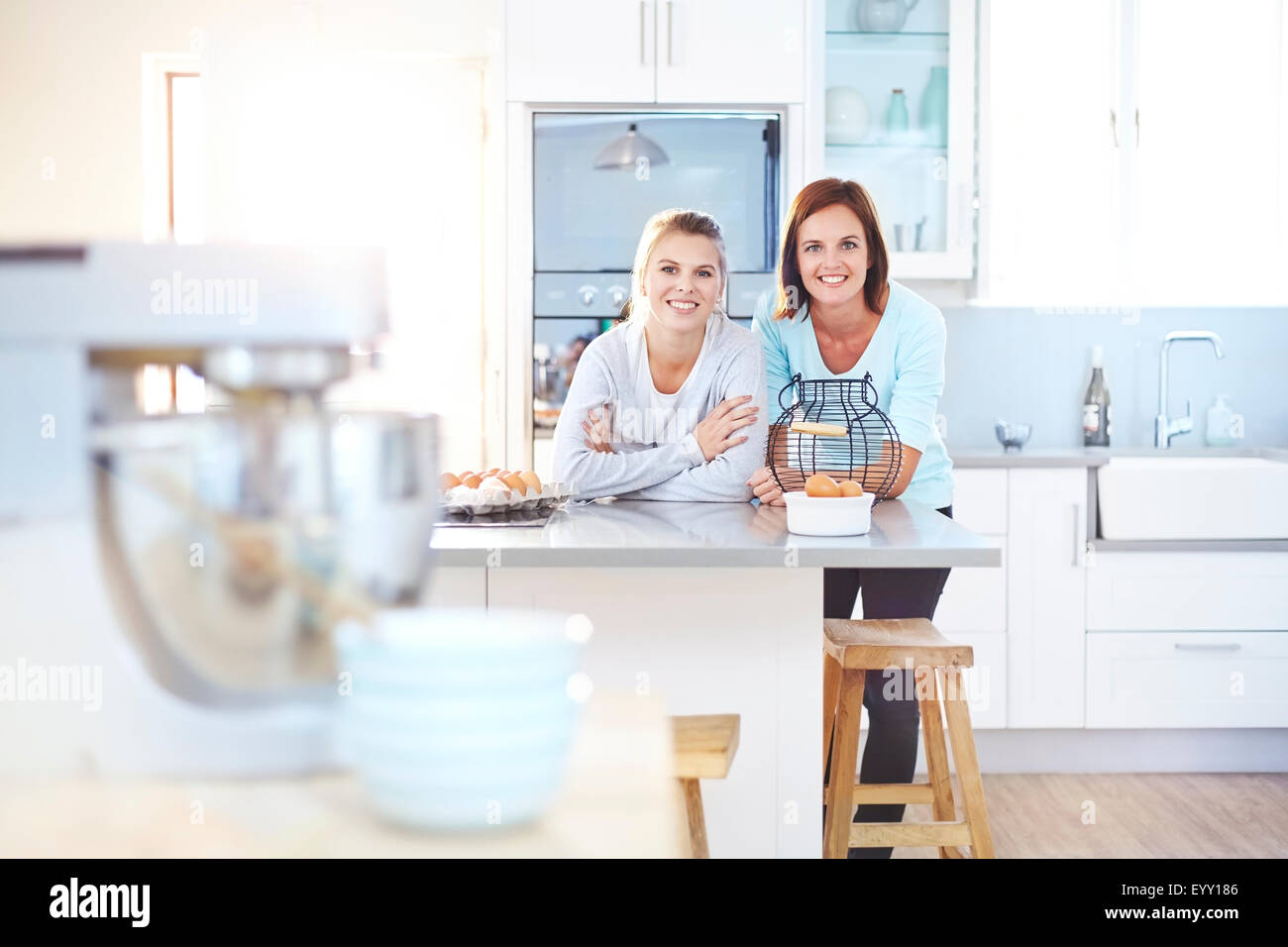 Portrait of smiling women leaning on kitchen counter Banque D'Images