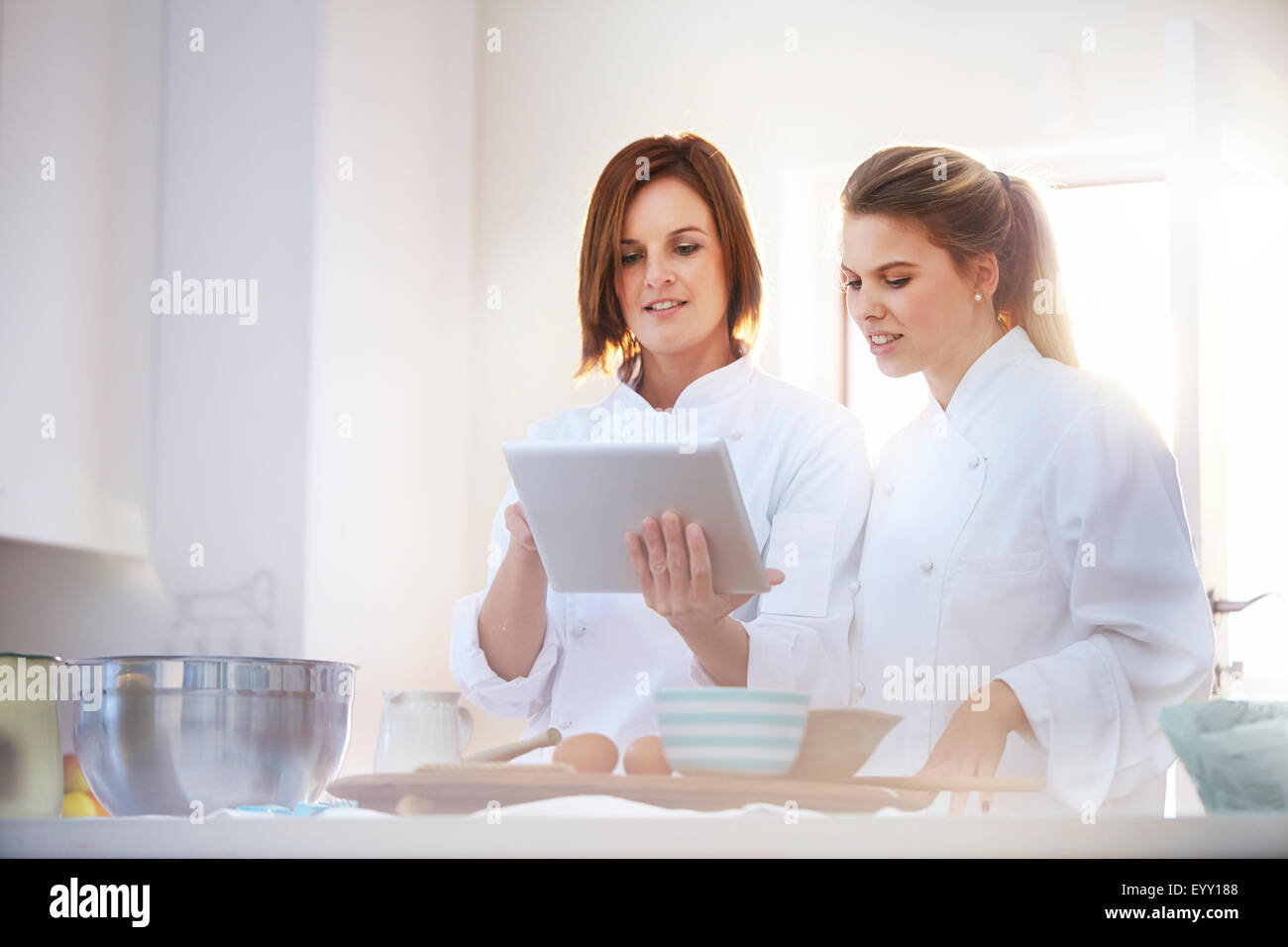 Chefs using digital tablet in kitchen Banque D'Images