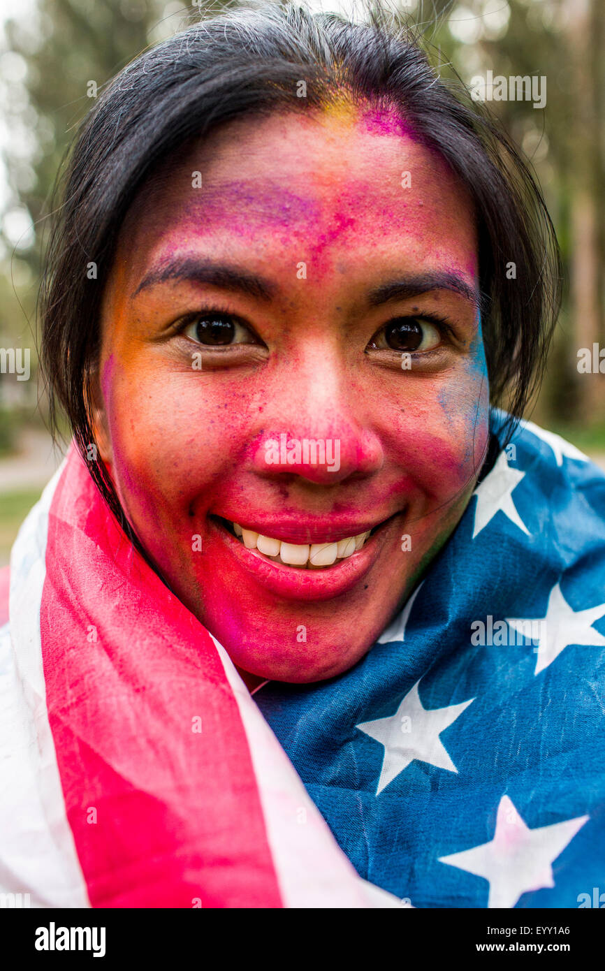 Smiling Asian woman couvert de poudre de pigment portant drapeau Américain Banque D'Images