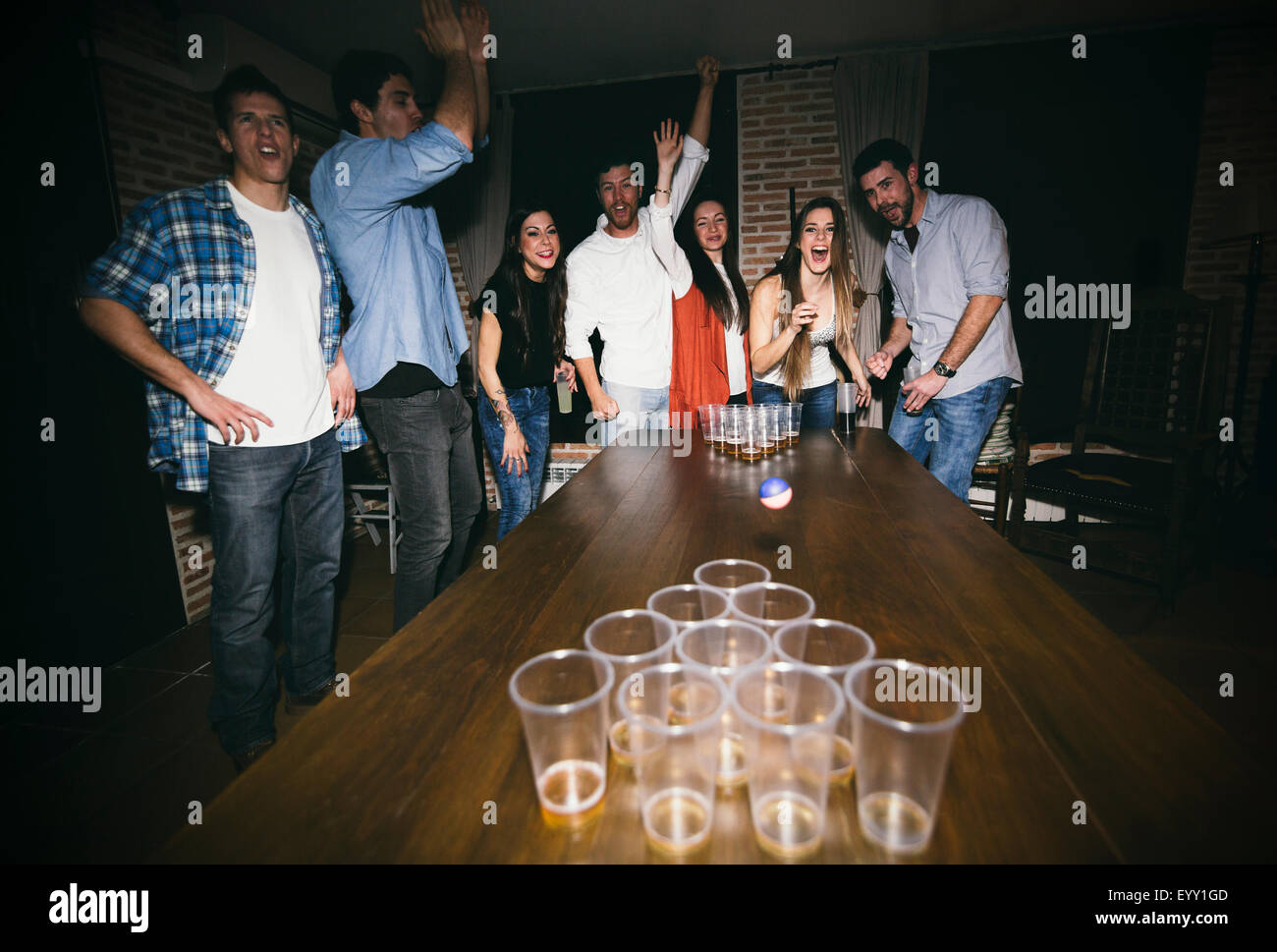 Amis jouant beer pong at party Banque D'Images