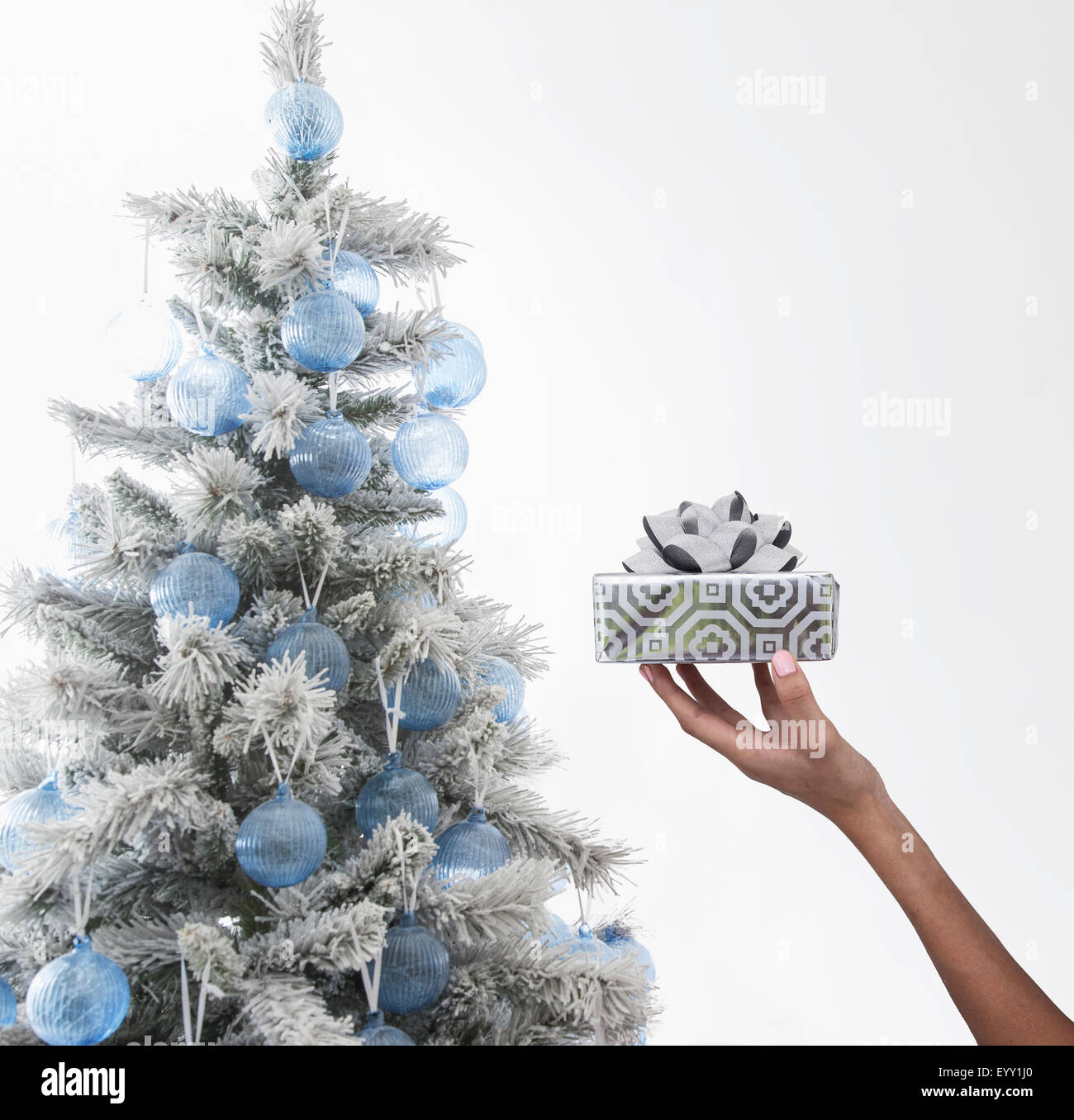 Caucasian woman holding wrapped gift near Christmas Tree Banque D'Images