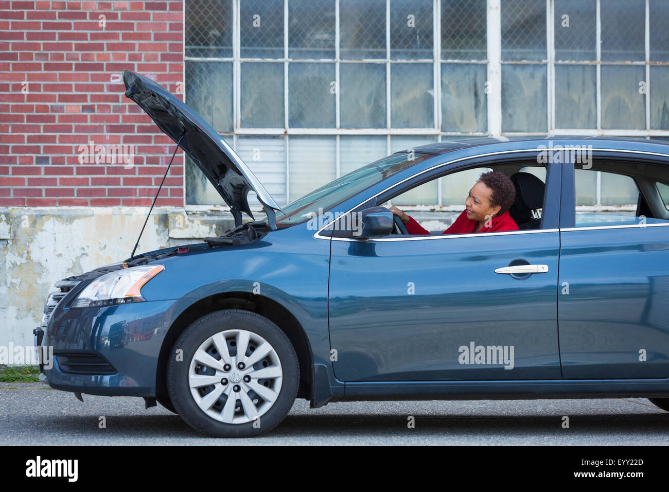 Black woman with broken down car Banque D'Images