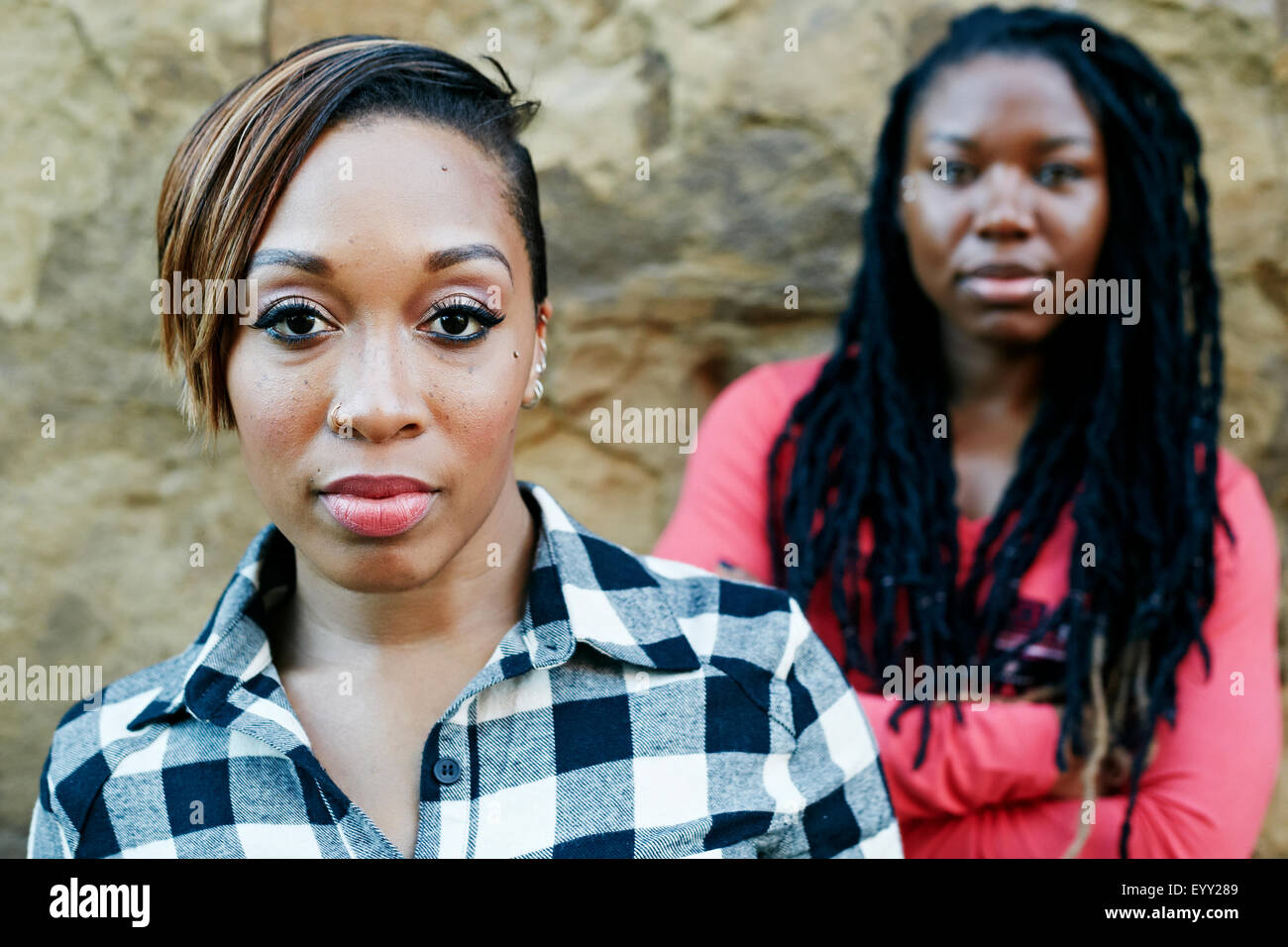 Femme sérieuse debout près de rock wall Banque D'Images