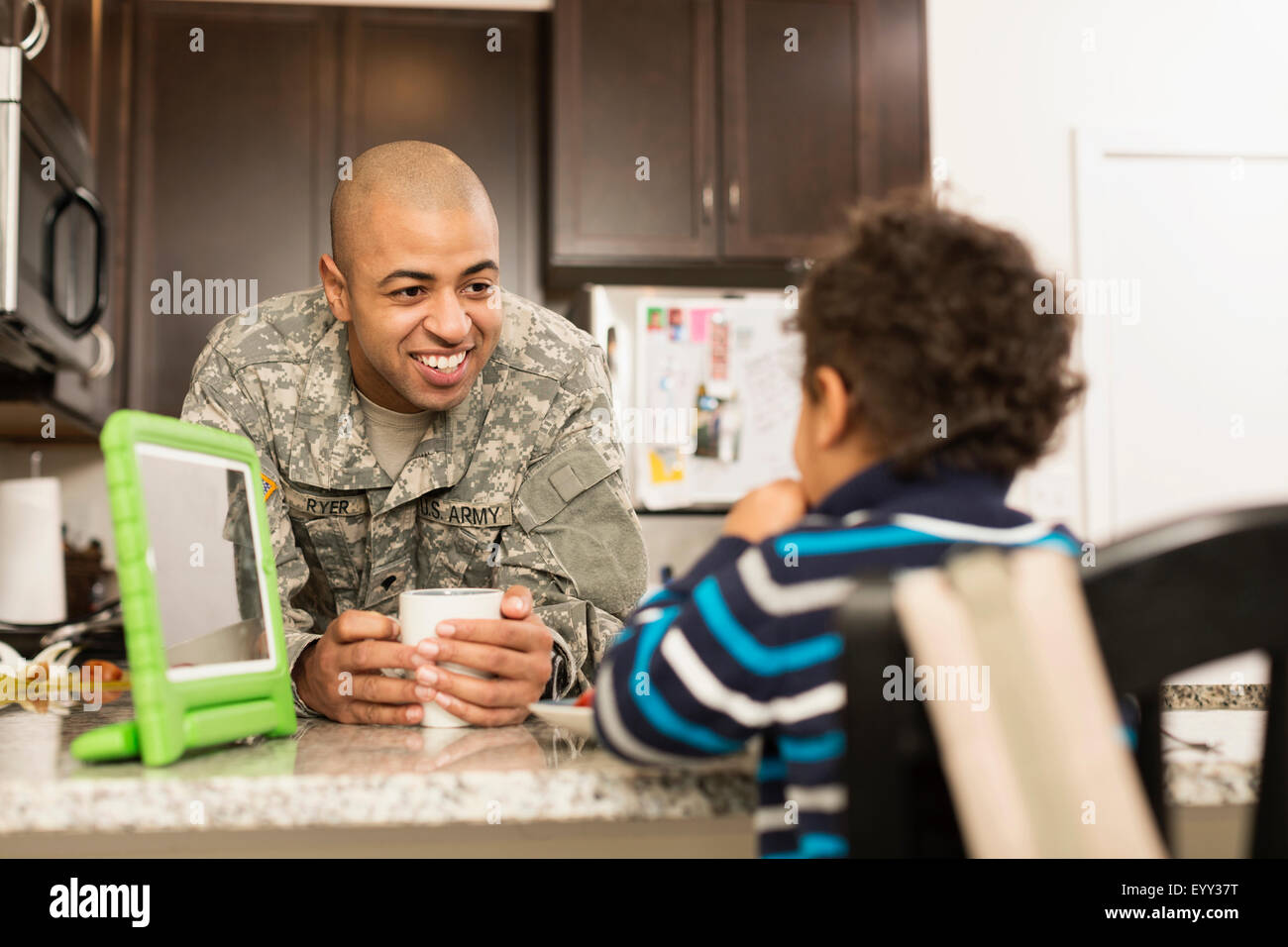 Mixed Race soldat père et fils de manger dans la cuisine Banque D'Images