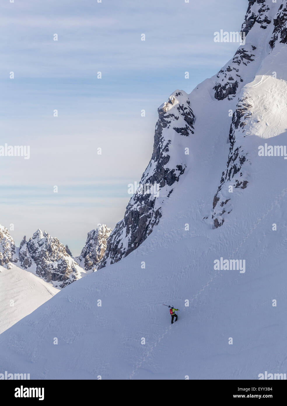 Caucasian climber scaling snowy mountain slope Banque D'Images