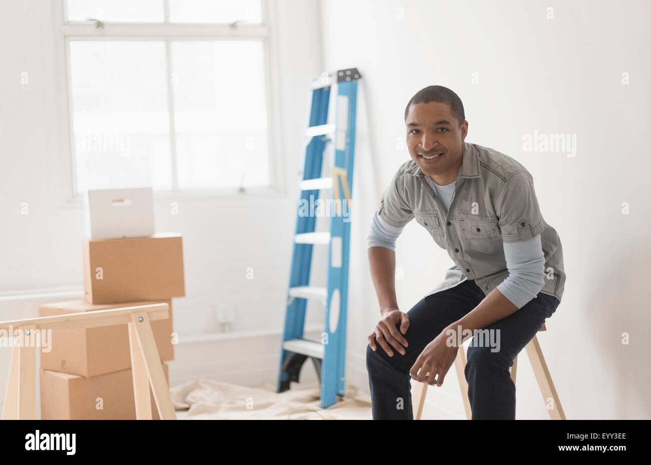 Homme noir assis dans la pièce en cours de rénovation Banque D'Images