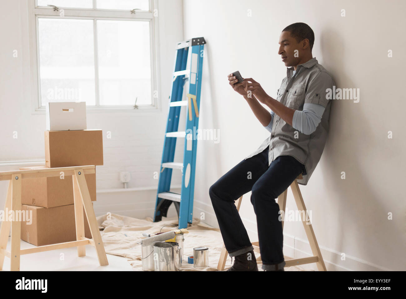 Homme noir assis dans la pièce en cours de rénovation Banque D'Images