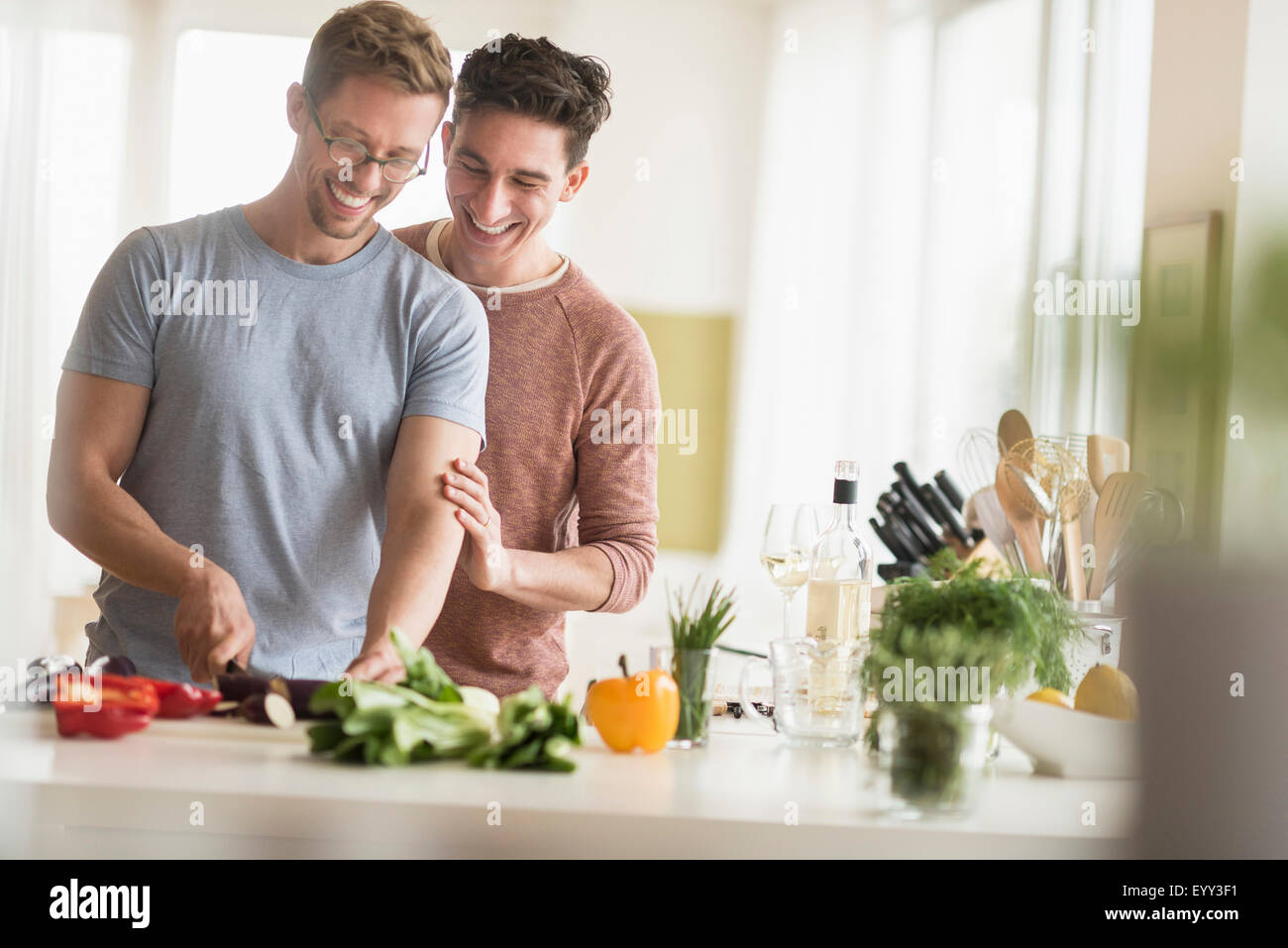 Caucasian couple gay cooking in kitchen Banque D'Images