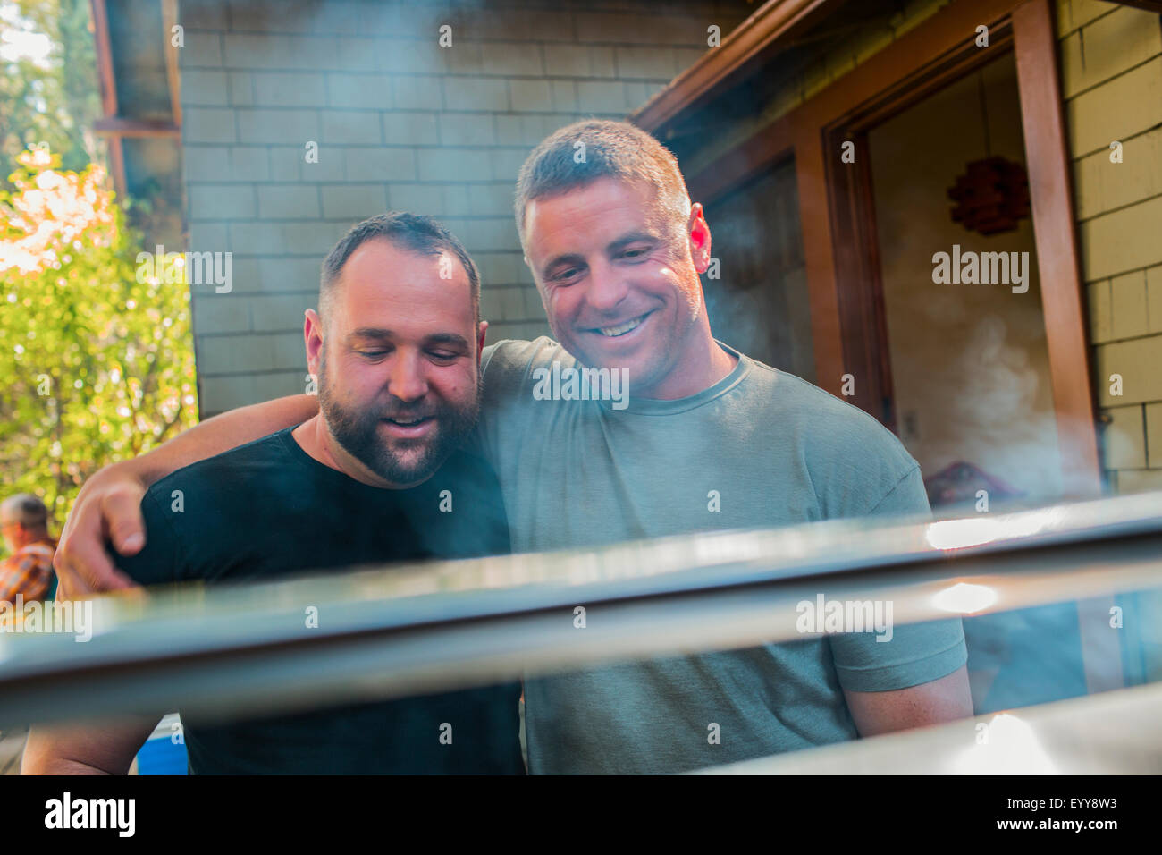 Gay couple grilling food in backyard Banque D'Images