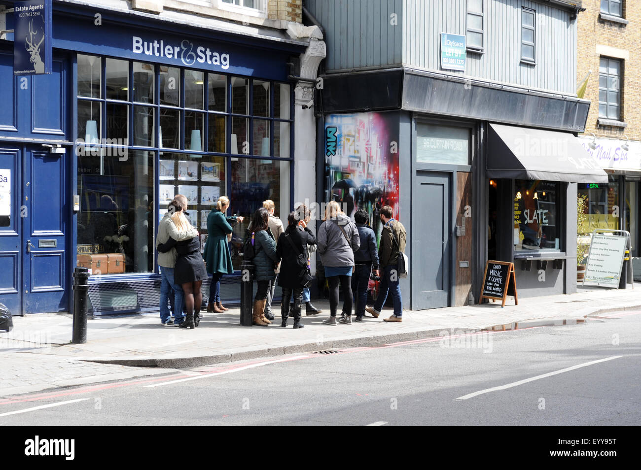 Un guide avec un groupe de touristes à pied autour de Brick Lane, le quartier de Shoreditch à l'Est de Londres à la recherche de pièces d'écriture Graffiti Banque D'Images