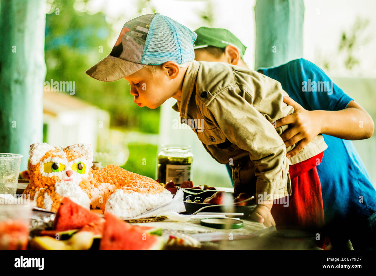 Woman blowing out candles on cake Banque D'Images