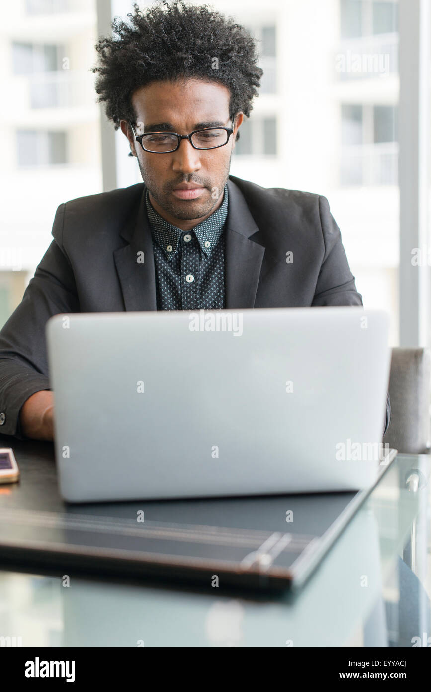 Hispanic businessman using laptop in office Banque D'Images