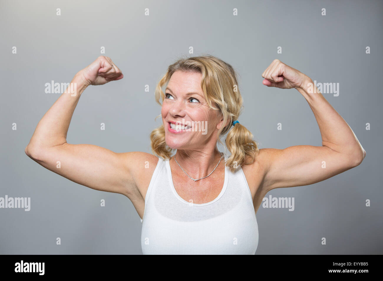 Smiling older woman flexing biceps Banque D'Images