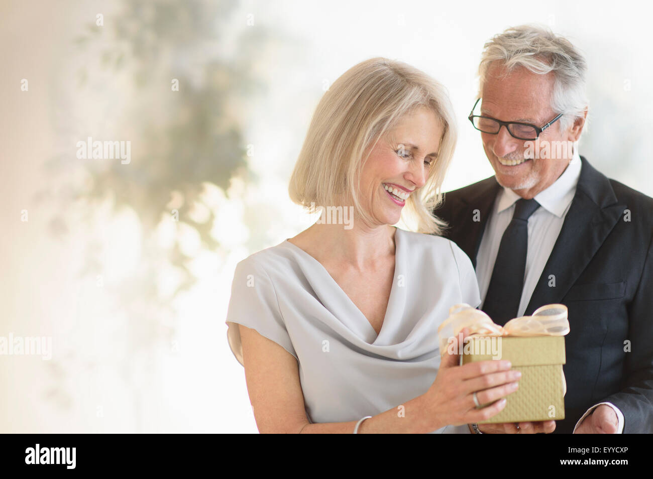 Smiling Caucasian man giving épouse un cadeau Banque D'Images