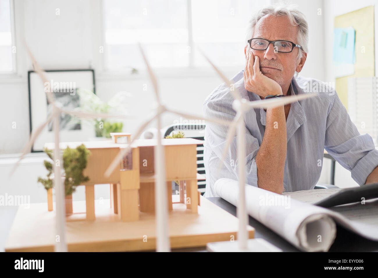 Caucasian architect examining scale model in office Banque D'Images