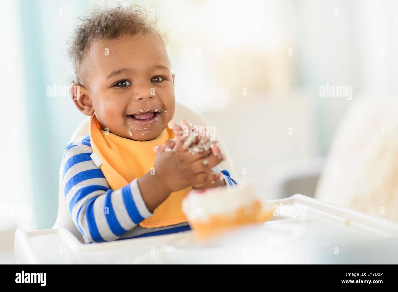 Mixed Race baby boy de manger dans une chaise haute Banque D'Images