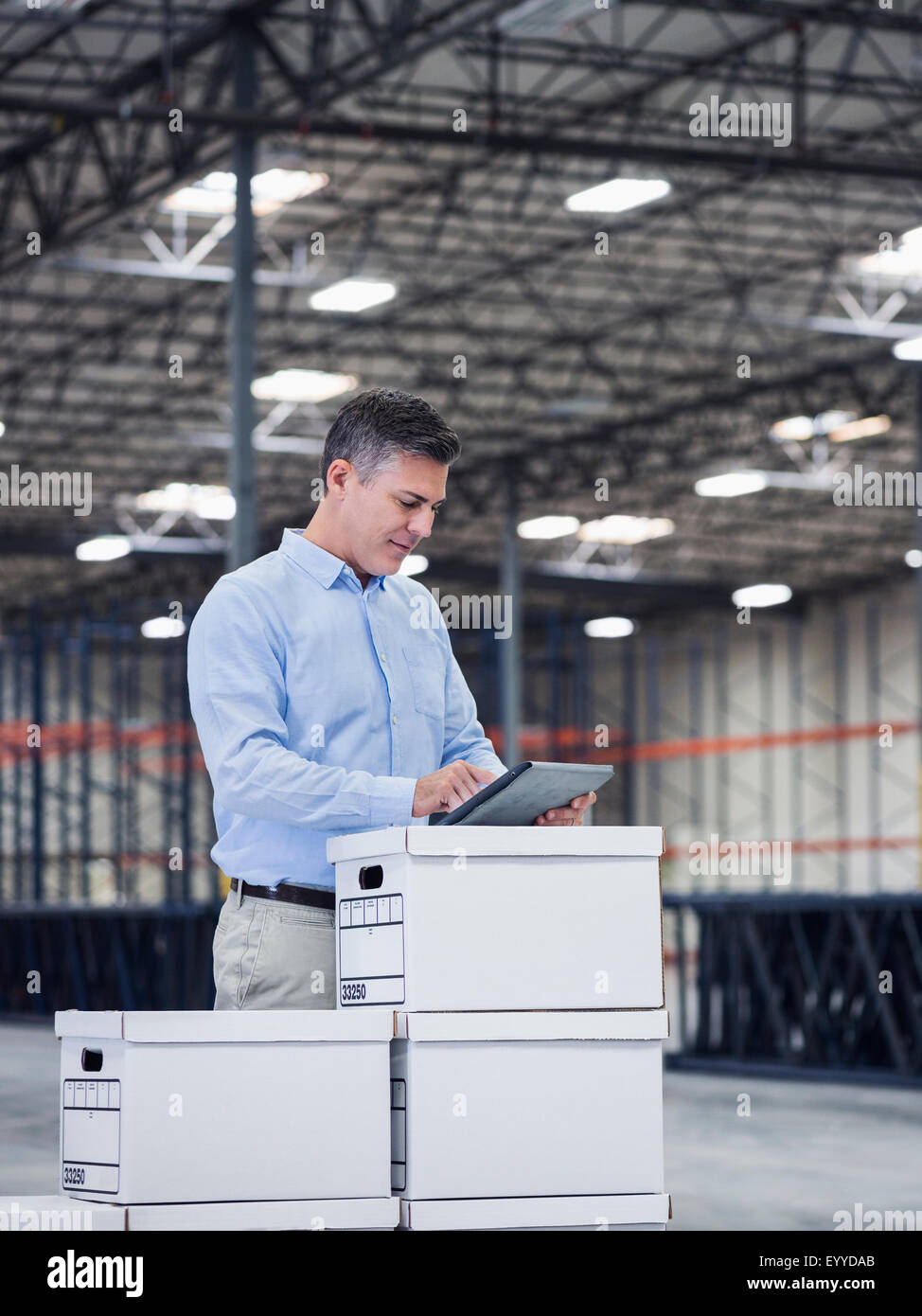 Caucasian businessman using digital tablet in empty warehouse Banque D'Images