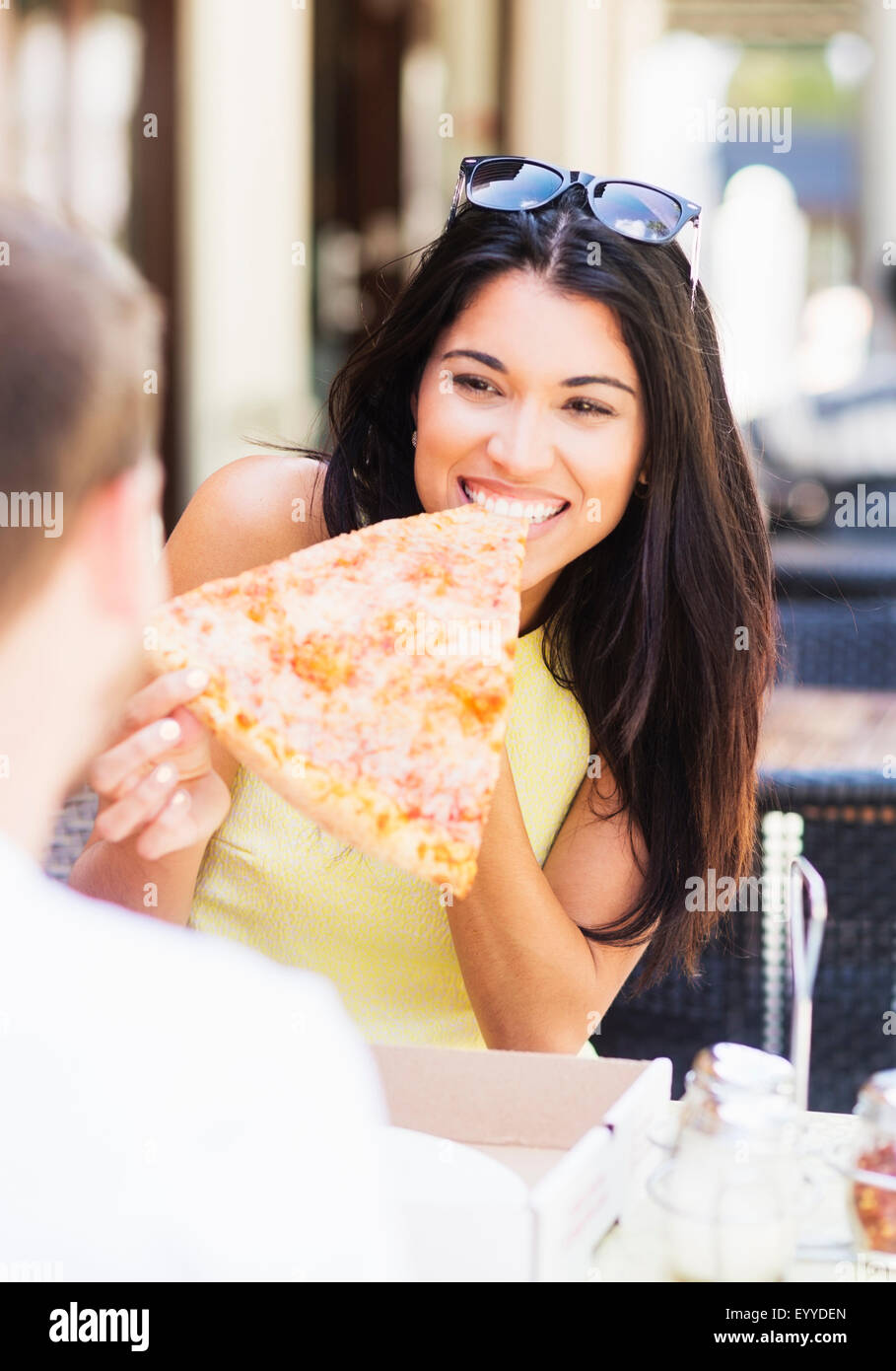 Hispanic couple eating pizza at cafe Banque D'Images