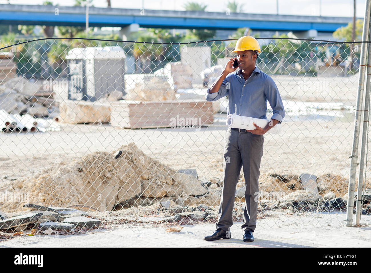 Architecte noir in hard hat talking on cell phone Banque D'Images