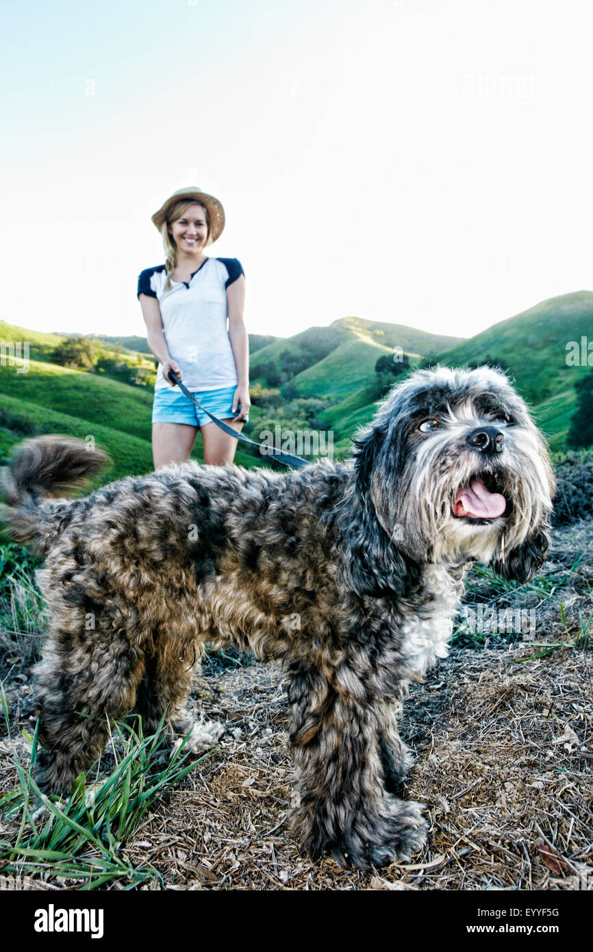Caucasian woman walking dog on rural hilltop Banque D'Images