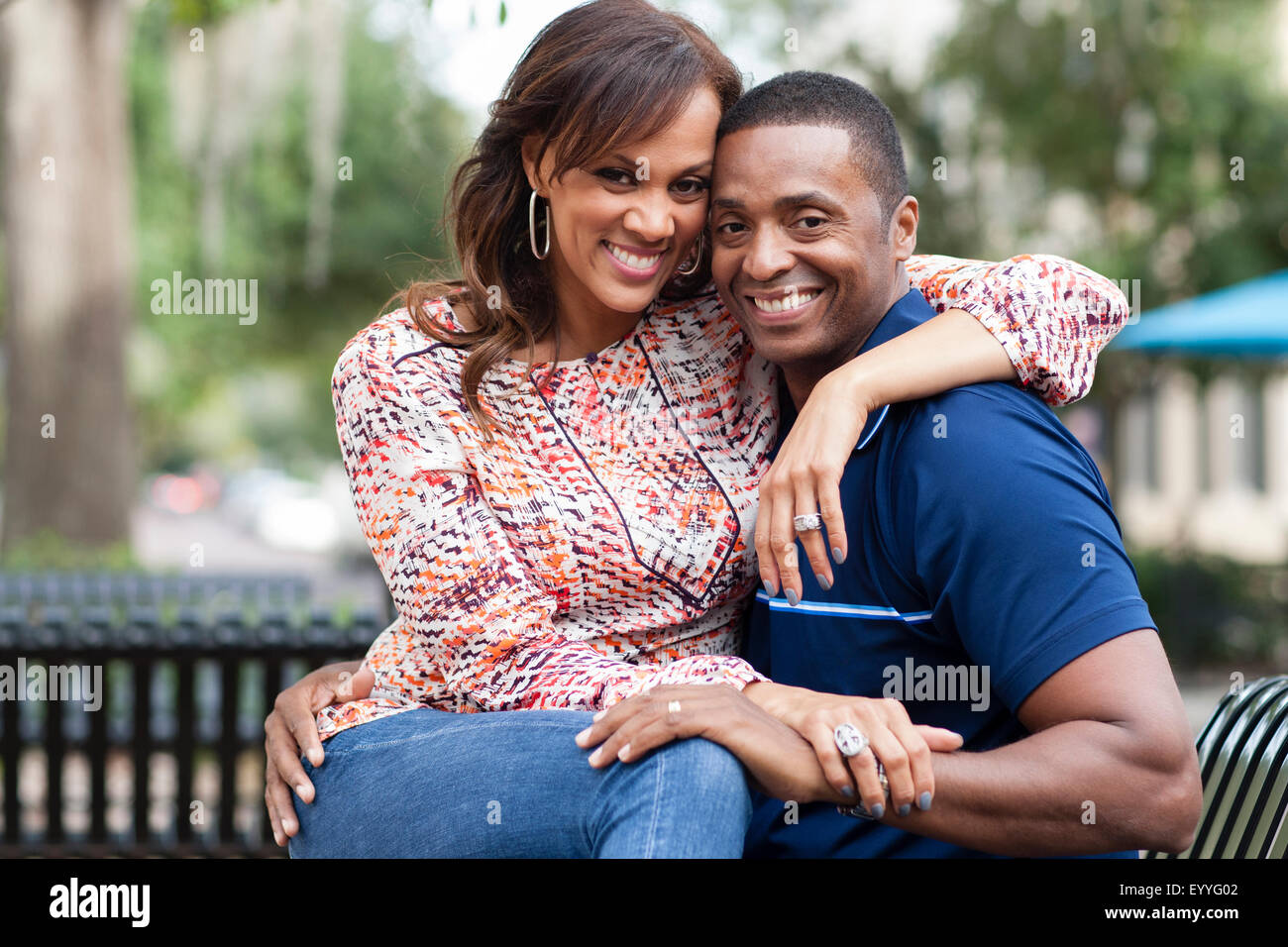 Smiling couple hugging on park bench Banque D'Images