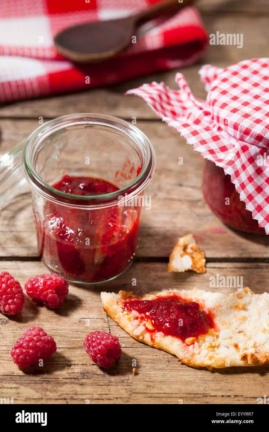 Confiture de framboises à la main dans le bocal et le biscuit aux amandes Banque D'Images