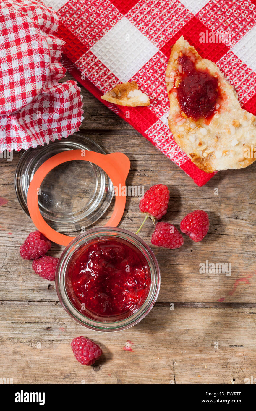 Confiture de framboises à la main dans le bocal et sur l'amande biscuit, vue d'en haut Banque D'Images