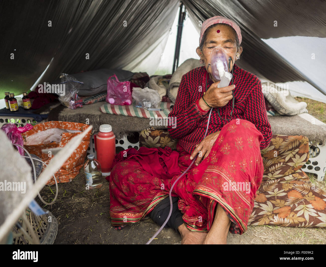 Katmandou, Népal. 5 Août, 2015. CHANDRA SUNAR MAYA, 57 ans, respire par un masque à oxygène dans sa tente dans un grand de personnes déplacées internes (IDP) Camp dans le centre de Katmandou. Elle est venue à Katmandou avec sa famille de Sindupalchok après le séisme. Le camp est à côté de l'un des plus coûteux les hôtels à Katmandou. Plus de 7 100 personnes déplacées par le tremblement de terre au Népal en avril vivent dans 1 800 tentes réparties dans l'espace de trois terrains de football. Credit : ZUMA Press, Inc./Alamy Live News Banque D'Images