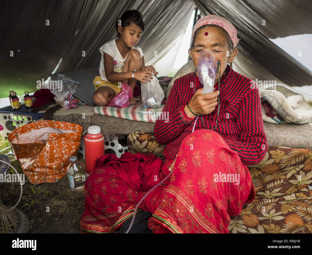 Katmandou, Népal. 5 Août, 2015. CHANDRA SUNAR MAYA, 57 ans, respire par un masque à oxygène dans sa tente dans un grand de personnes déplacées internes (IDP) Camp dans le centre de Katmandou. Elle est venue à Katmandou avec sa famille de Sindupalchok après le séisme. Le camp est à côté de l'un des plus coûteux les hôtels à Katmandou. Plus de 7 100 personnes déplacées par le tremblement de terre au Népal en avril vivent dans 1 800 tentes réparties dans l'espace de trois terrains de football. Credit : ZUMA Press, Inc./Alamy Live News Banque D'Images