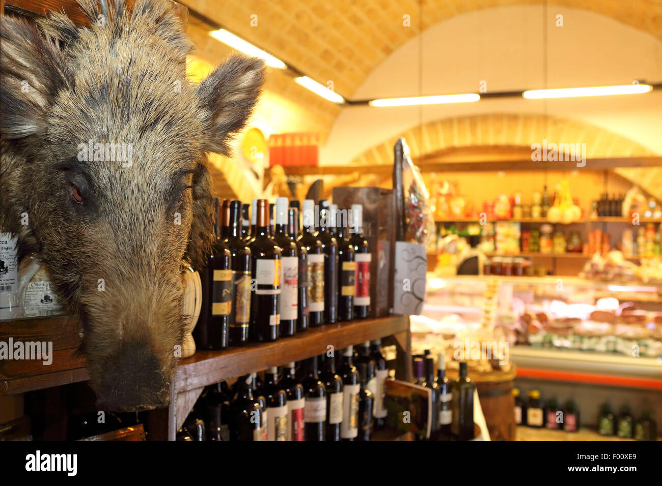 Une tête de sanglier, bouteilles de vin et de l'épicerie fine compteur dans l'Antica Salumeria del Gusto à Bari, Italie. Banque D'Images