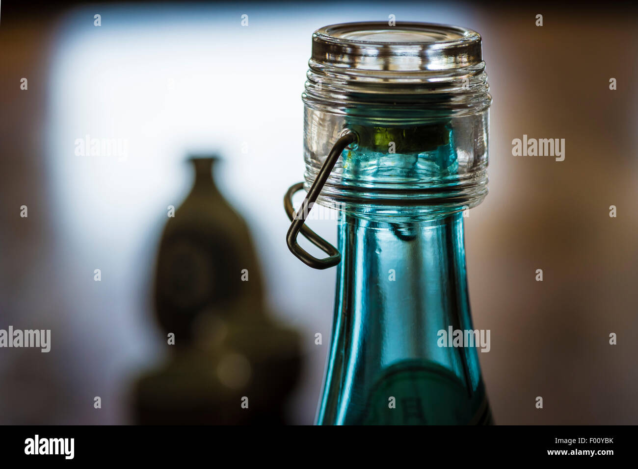 Une bouteille de boisson alcoolisée japonaise le souci et en céramique tasses de saké dans le rétro-éclairage sur une table en bois sombre. Banque D'Images