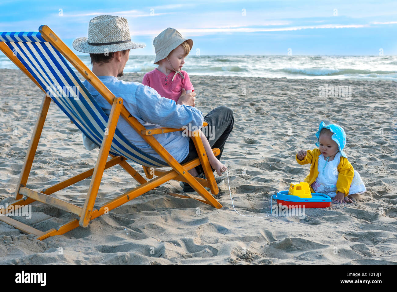 Père jouissant d'un soir d'été à la plage avec ses enfants Banque D'Images