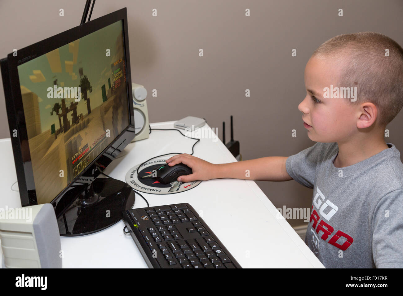 Jeune garçon (7 ans) Jouer un jeu vidéo. M. Banque D'Images