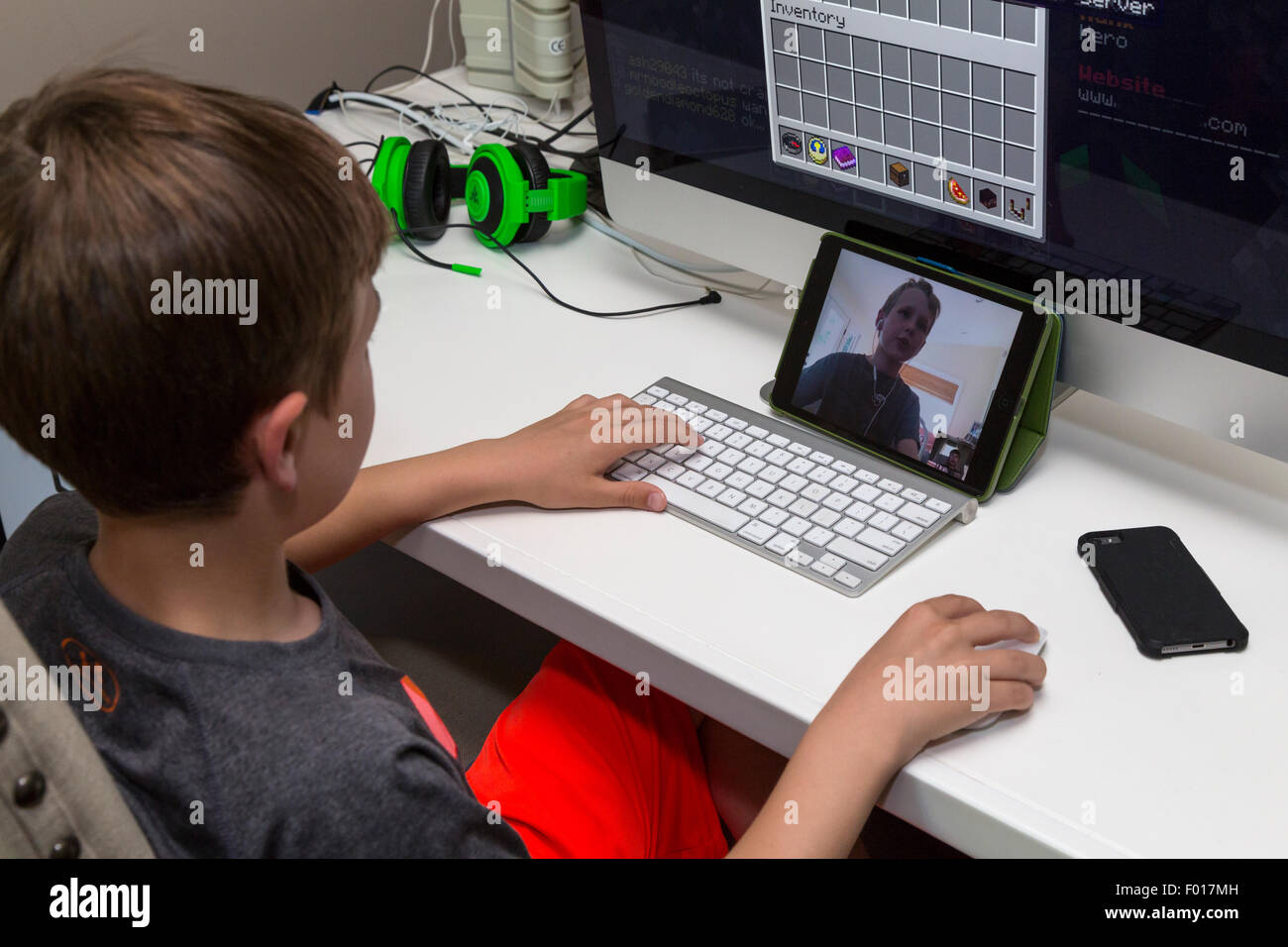 Deux jeunes garçons jouent à des jeux vidéo à longue distance, la communication via Facetime. M. Banque D'Images