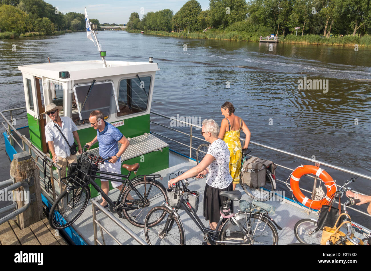 Amsterdam, Location de vélo petit traversier sur la rivière Amstel, à seulement dans les limites de la ville. Banque D'Images