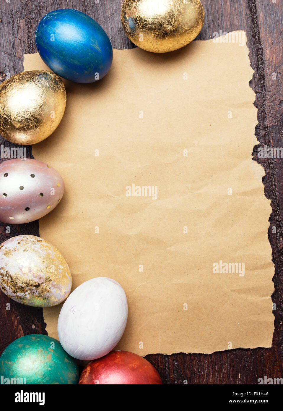 Les oeufs de Pâques sur table en bois avec le papier blanc pour le texte. Arrière-plan de vacances Banque D'Images