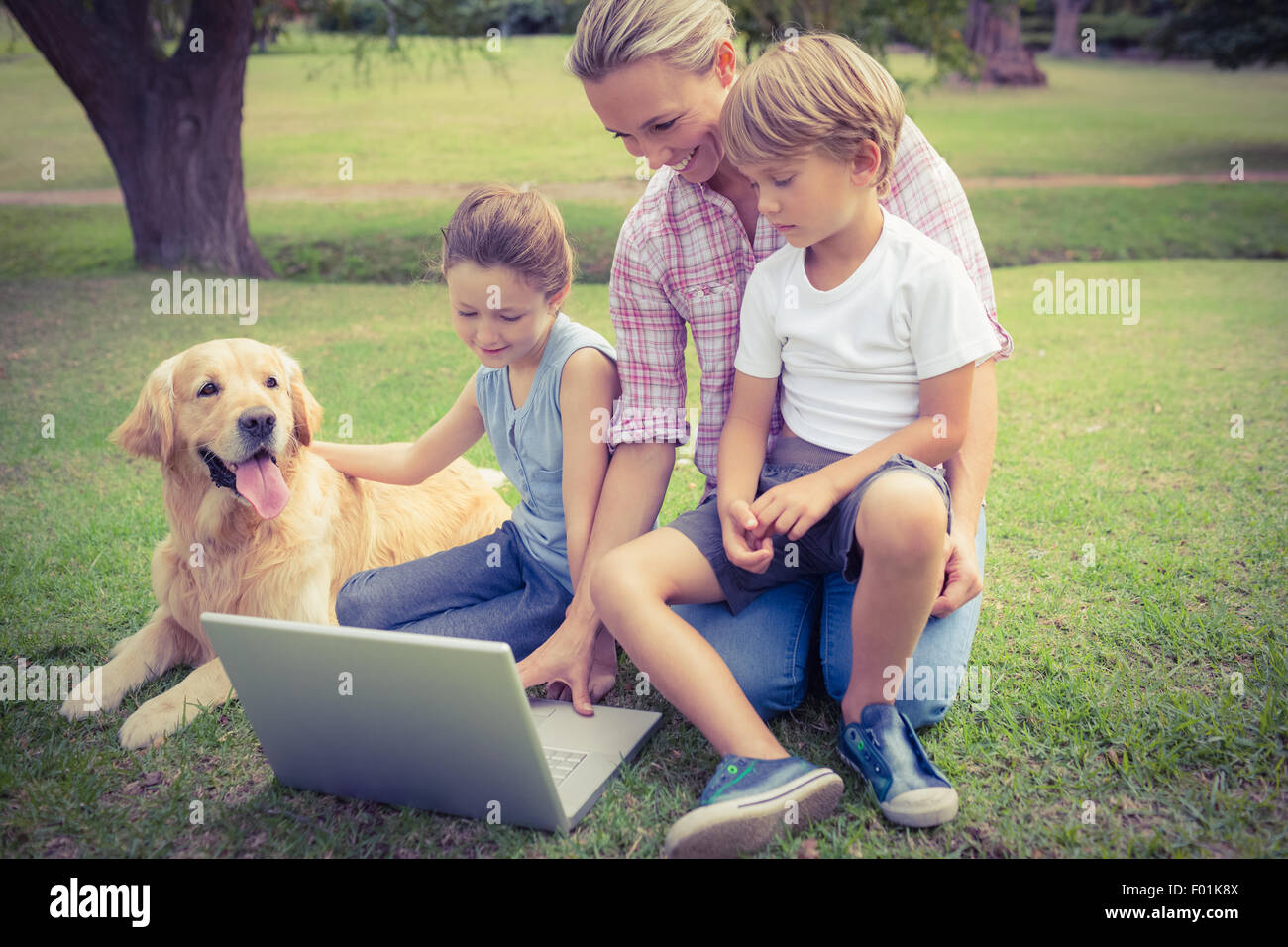 Famille heureuse avec leur chien using laptop Banque D'Images